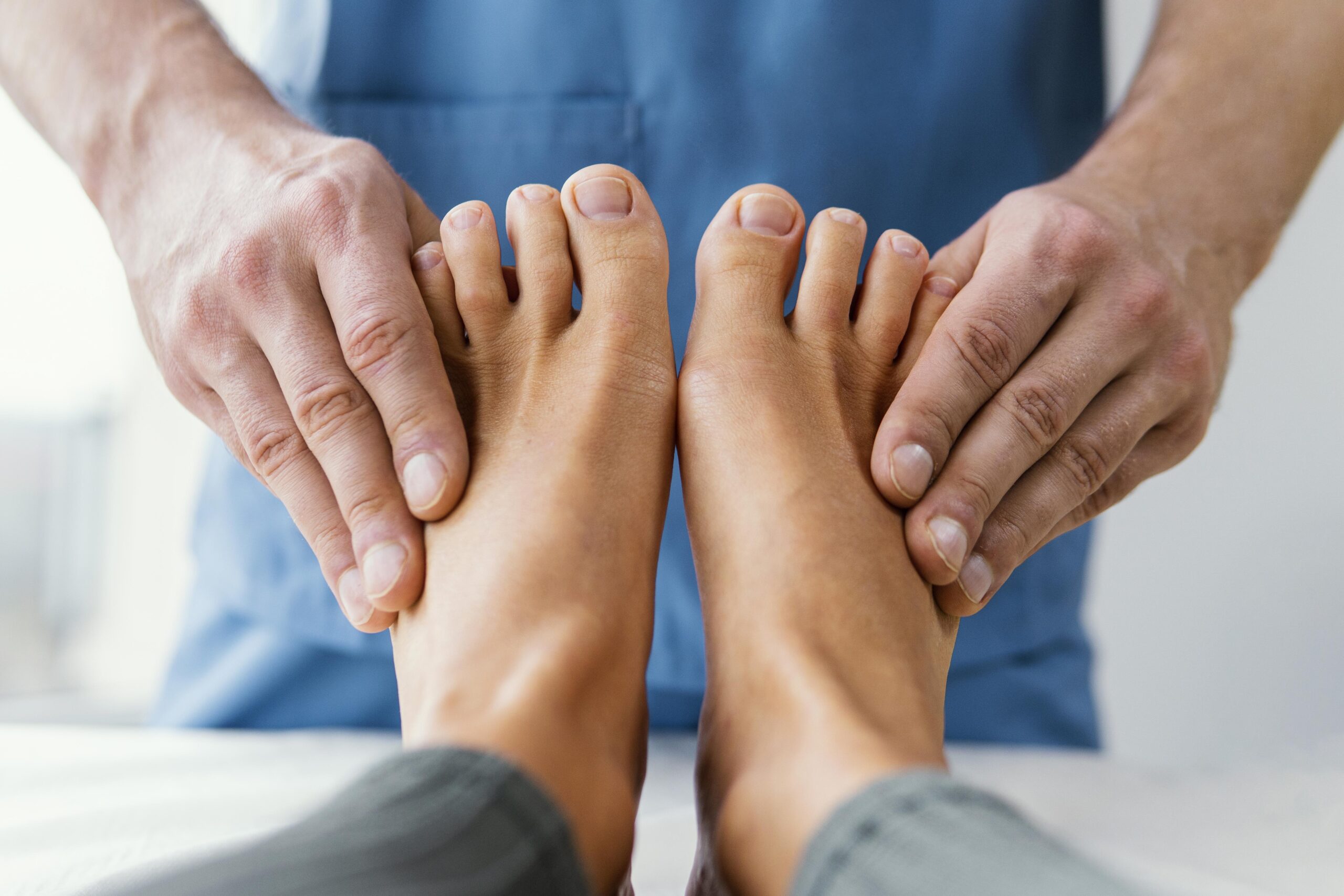 front-view-male-osteopathic-therapist-checking-female-patient-s-toes
